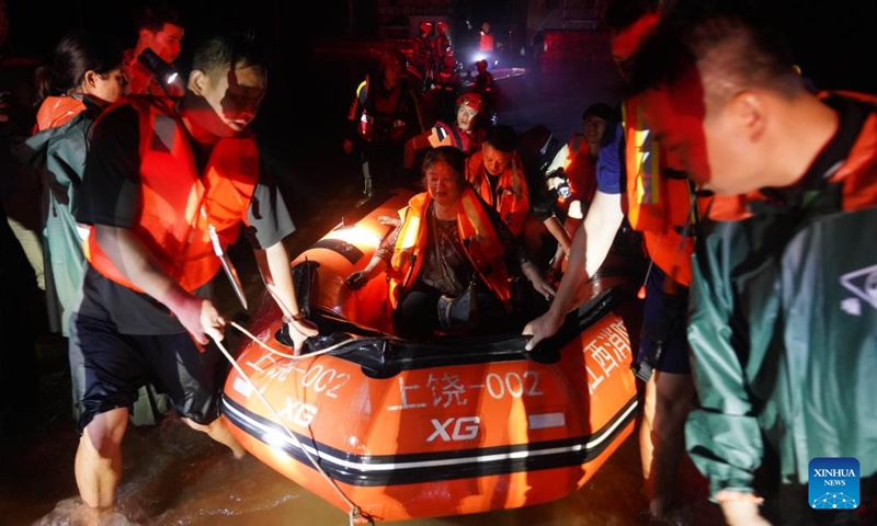 Rescuers evacuate stranded people in flood water in Dexing, east China's Jiangxi Province, June 20, 2022. East China's Jiangxi Province on Monday issued a red alert for floods, as local hydrological stations registered water in local rivers at warning levels. The heavy rain that lashed Jiangxi has brought the first floods this year in Changjiang River and Xiuhe River in the province, according to the provincial hydrological monitoring center.(Photo: Xinhua)