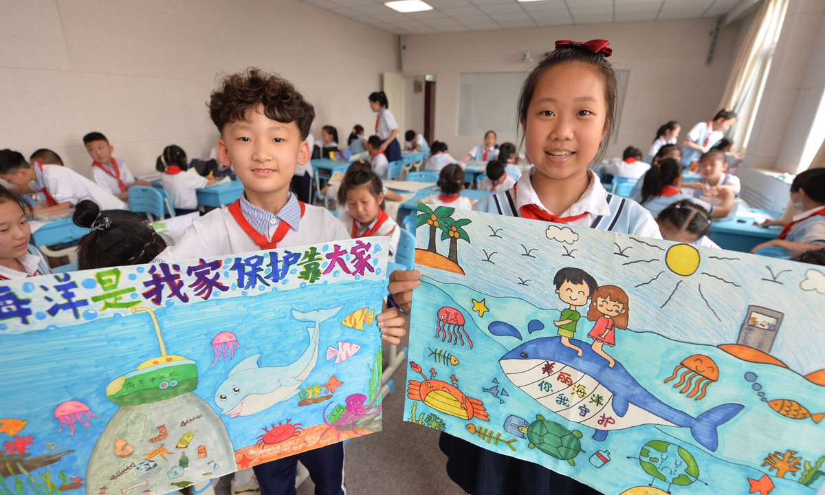 Two students in Qingdao, a coastal city in East China's Shandong Province, hold a poster that advocates marine protection on June 8, 2022, which marks World Oceans Day. The day is designed to raise awareness about ending overfishing and protecting our oceans. Photo: VCG