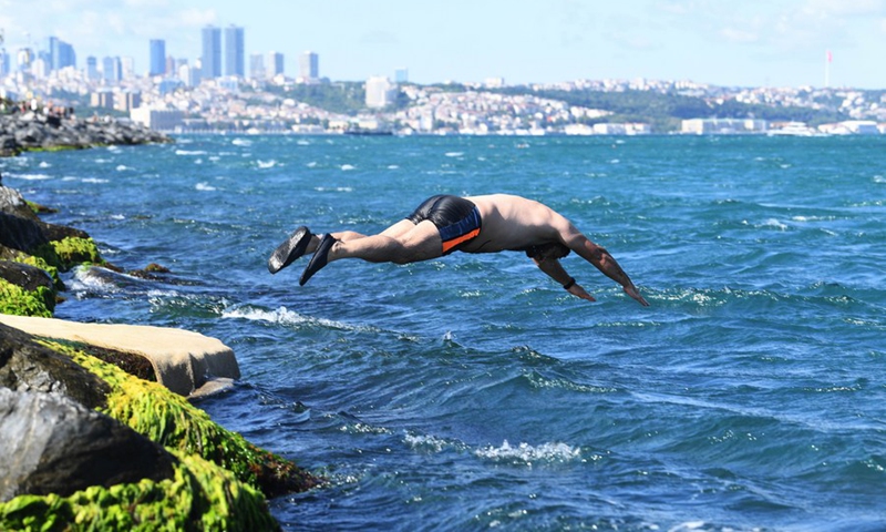 A man jumps into the Bosphorus Strait in Istanbul, Turkey on June 18, 2022.(Photo: Xinhua)