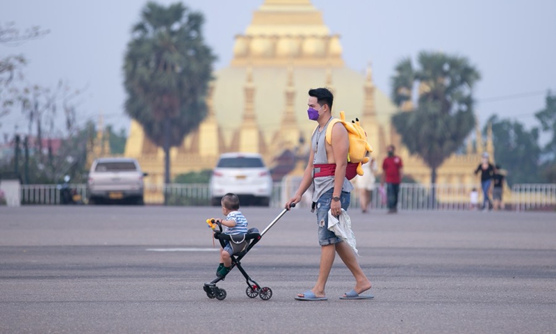 Citizens walk on That Luang Square in the downtown area of Vientiane, Laos, April 10, 2022.(Photo: Xinhua)