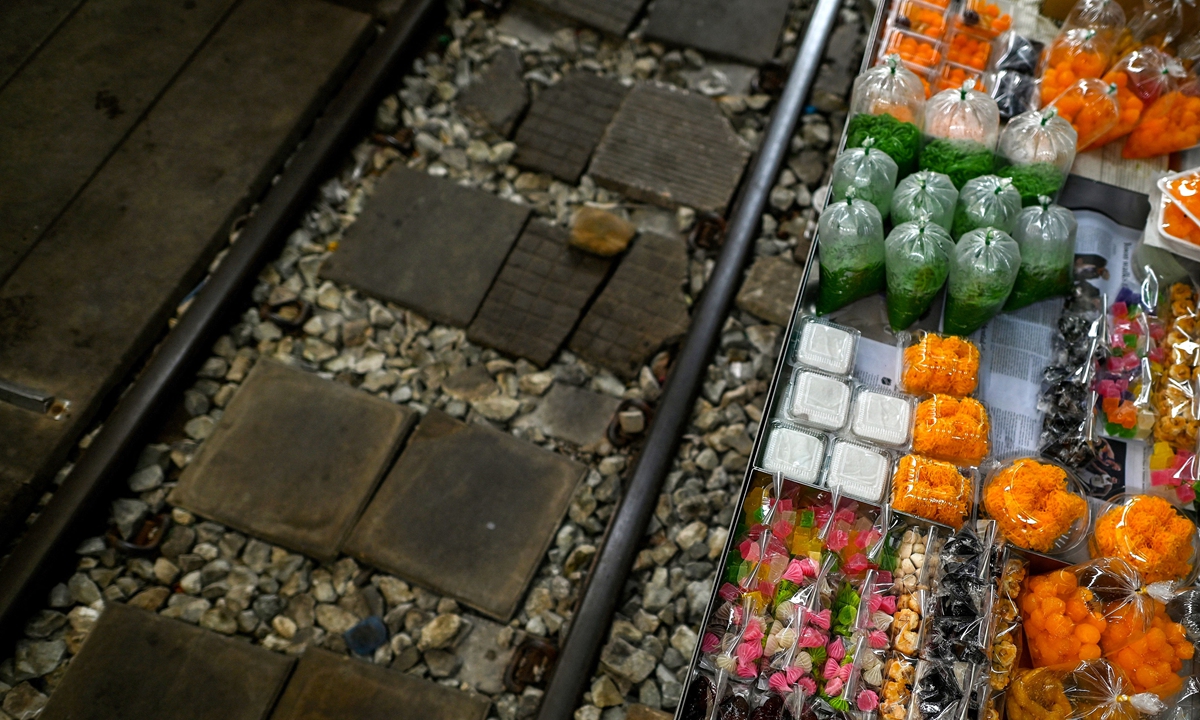 Desserts are for sale next to the train tracks of the Mae Klong Railway Market, on June 4, 2022. Photo: AFP
