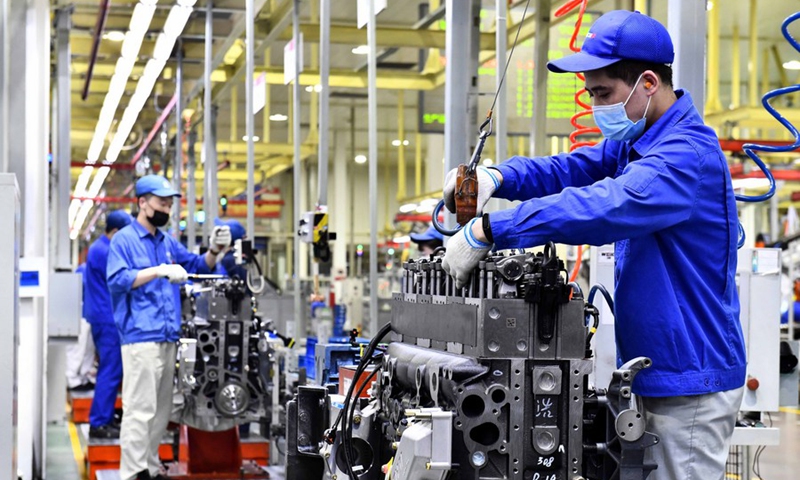 Workers assemble engines on an assembly line at a workshop of the Weichai Power Co., Ltd. in Weifang City, east China's Shandong Province, April 22, 2021. (Xinhua/Guo Xulei)