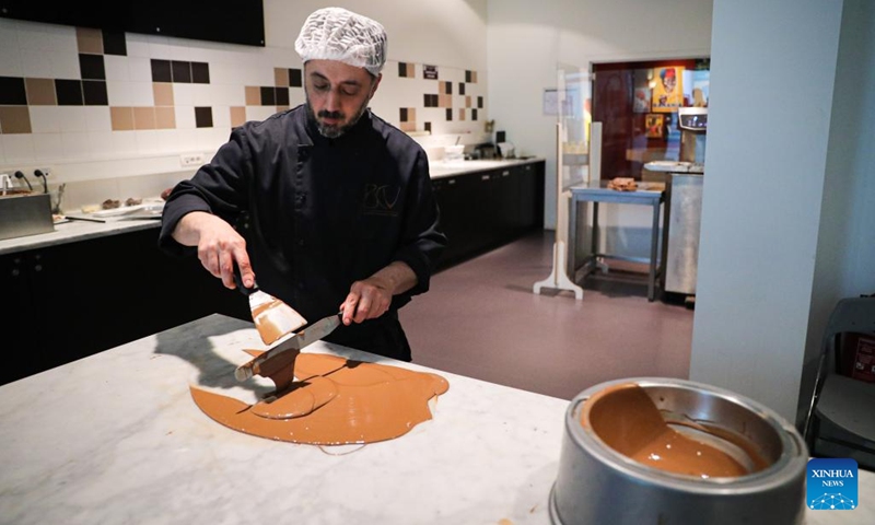 A staff member shows the making of chocolate in the Belgian Chocolate Village in Brussels, Belgium, June 9, 2022. The Belgian Chocolate Village is a museum to showcase the knowledge, history and culture related to chocolate.(Photo: Xinhua)