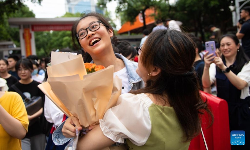 An examinee (L) receives a bunch of flowers from her parent out of an exam site of national college entrance exam in Changsha, central China's Hunan Province, June 9, 2022. The annual exam, better known as the gaokao, saw a record 11.93 million candidates signing up this year.(Photo: Xinhua)