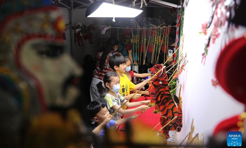 Children try to handle shadow play at Anhui Museum in Hefei, capital of east China's Anhui Province, June 11, 2022.Photo:Xinhua