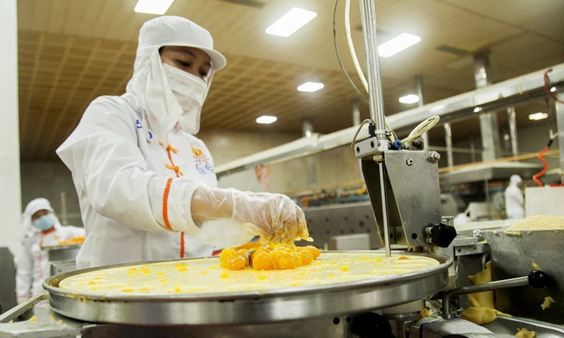 A worker processes salted egg yolks to make traditional Pia cake at a production base in southern Vietnam's Soc Trang province on April 28, 2022.Photo:Xinhua