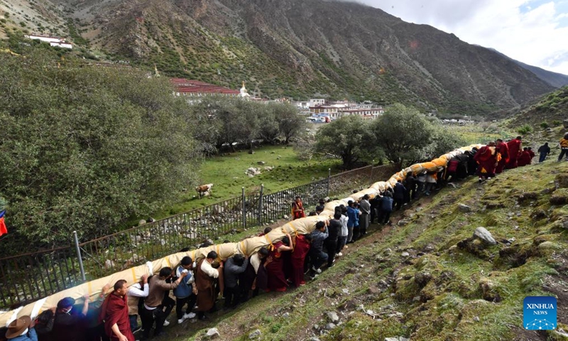 Monks and Buddhism followers attend an annual Buddha thangka displaying ritual at the Tsurphu Monastery in southwest China's Xizang Autonomous Region, June 11, 2022.Photo:Xinhua