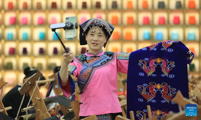 A staff member presents tapestry weaving of Tujia ethnic group through live streaming at Wulingyuan of Zhangjiajie, central China's Hunan Province, June 11, 2022.Photo:Xinhua