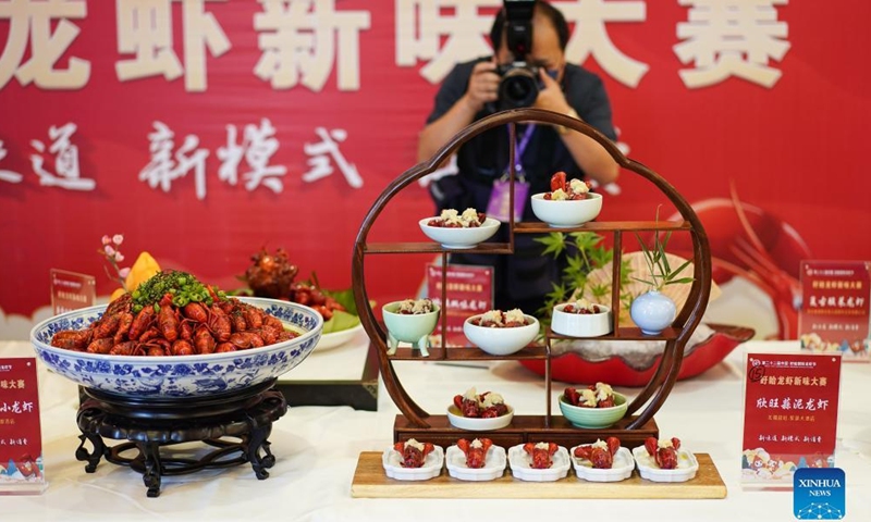 A journalist takes photos of crayfish dishes showcased during an international crayfish festival in Xuyi County of Huai'an, east China's Jiangsu Province, June 12, 2022.Photo:Xinhua