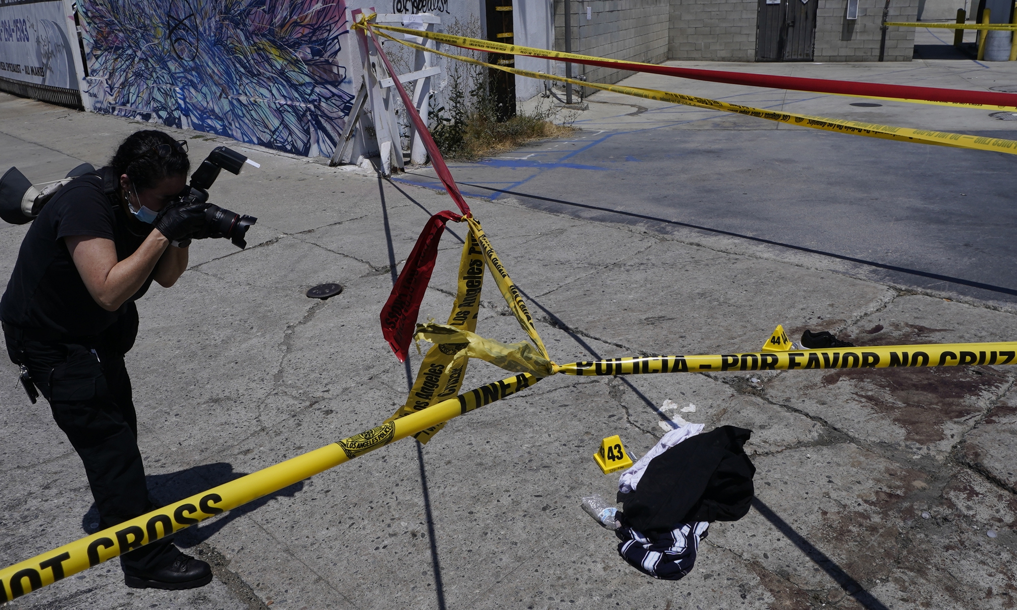 A Los Angeles Police field forensic photographer documents evidence after a shooting at a warehouse party in Los Angeles on June 12, 2022. Three people were killed and four others wounded in the latest mass shooting in the US. Photo: VCG