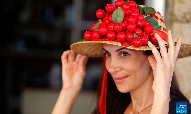 A woman shows a cherry hat at the Hammana Cherry Festival in the village of Hammana, Mount Lebanon Governorate, Lebanon, on June 12, 2022.Photo:Xinhua