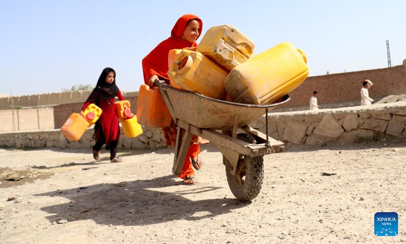 Afghan children go to receive water from a water tanker in Nangarhar province, Afghanistan, June 14, 2022. According to local officials, about 9 districts in Nangarhar province have been striken by drought this year.(Photo: Xinhua)
