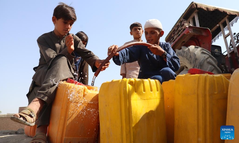 Afghan children receive water from a water tanker in Nangarhar province, Afghanistan, June 14, 2022. According to local officials, about 9 districts in Nangarhar province have been striken by drought this year.(Photo: Xinhua)