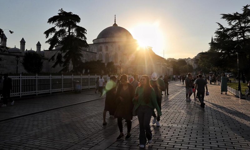 Tourists walk past the Blue Mosque at sunset in Istanbul, Turkey, on June 14, 2022.(Photo: Xinhua)