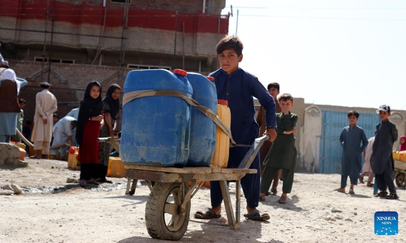 An Afghan child pushes a cart loaded with barrels in Nangarhar province, Afghanistan, June 14, 2022. According to local officials, about 9 districts in Nangarhar province have been striken by drought this year.(Photo: Xinhua)