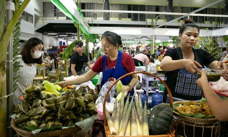 Visitors buy food at a booth during the Lancang-Mekong International Food Exposition in Vientiane, Laos, June 12, 2022.(Photo: Xinhua)