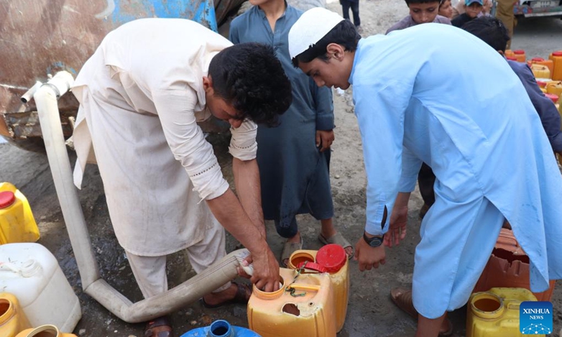 Afghan children receive water from a water tanker in Nangarhar province, Afghanistan, June 14, 2022. According to local officials, about 9 districts in Nangarhar province have been striken by drought this year.(Photo: Xinhua)