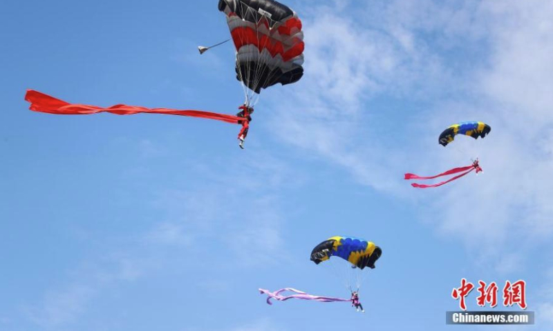 Women parachutists in traditional Chinese costumes perform during the 2022 Jiangxi Aviation Sports Tourism Festival in Ji'an, east China's Jiangxi Province, June 14, 2022. The festival opened on Tuesday in Jiangxi. (Photo: China News Service/Liu Zhankun)