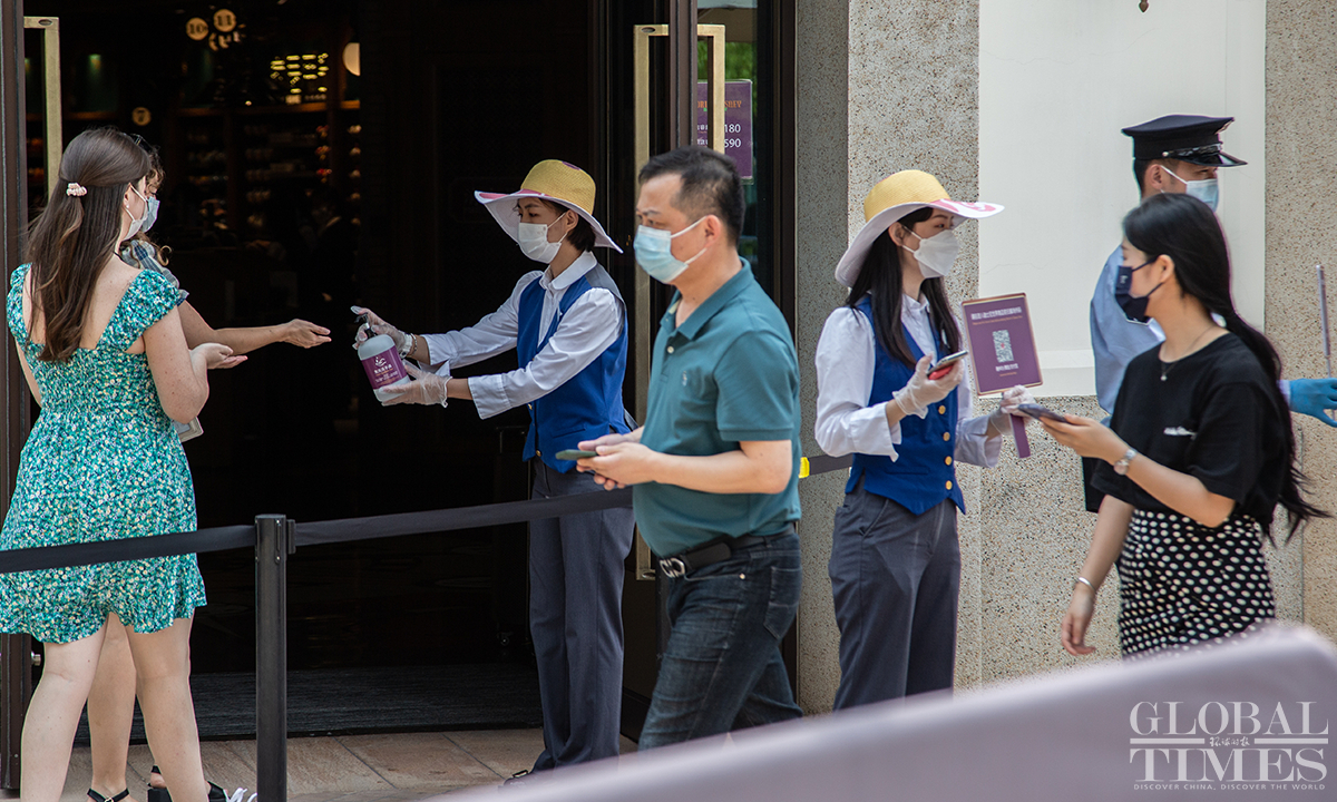 Visitors need to scan the health QR code and have disinfection whenever they enter a new place inside the Shanghai Disney Resort on June 16. Photo: Wu Shiliu