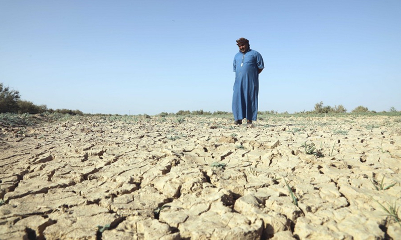 A farmer stands in the middle of his farm, which looks cracked due to drought and water shortage in Salahudin province, Iraq, June 14, 2022. (Xinhua/Xinhua)