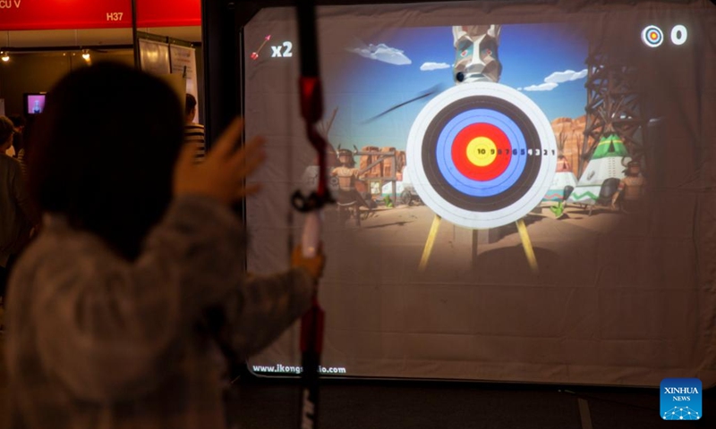 A visitor tries indoor archery during the Metaverse Expo 2022 held in Seoul, South Korea, June 15, 2022. The expo is held at the Coex Convention & Exhibition Center from June 15 to 17, presenting visitors with metaverse technologies in various scenarios.(Photo: Xinhua)