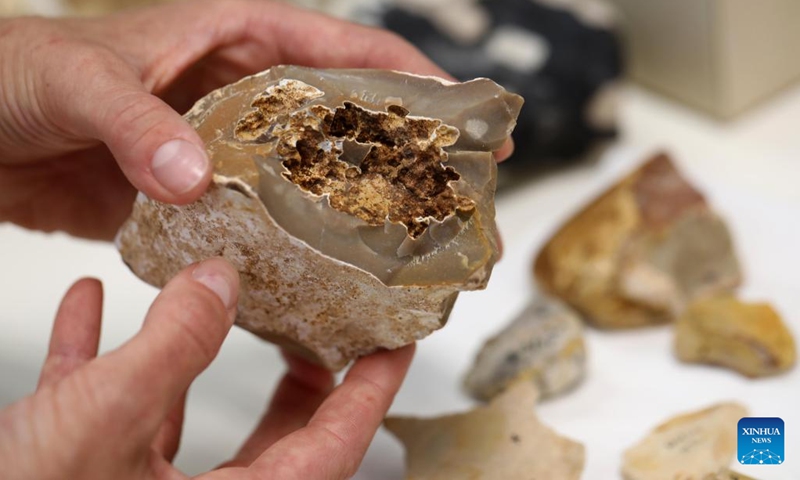 An Israeli researcher shows a piece of flint tools with traces of fire use at Weizmann Institute of Science in Rehovot, Israel, on June 15, 2022. Israeli researchers have found traces of fire use dating back at least 800,000 years ago with artificial intelligence (AI), the Weizmann Institute of Science (WIS) in central Israel said on Monday.(Photo: Xinhua)