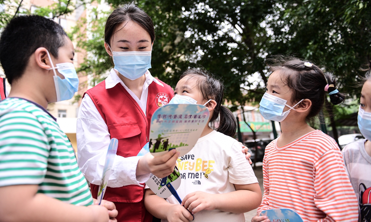 An university volunteer who actively respond to the school's call of returning home social practice activities tells stories to children in a community in Shenyang, Northeast China's Liaoning Province, on August 23, 2021. Photo: VCG 