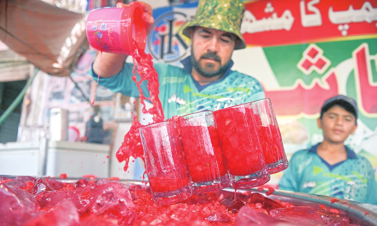 A vendor prepares to serve Rooh Afza watermelon beverages to customers in Karachi.Photo: AFP