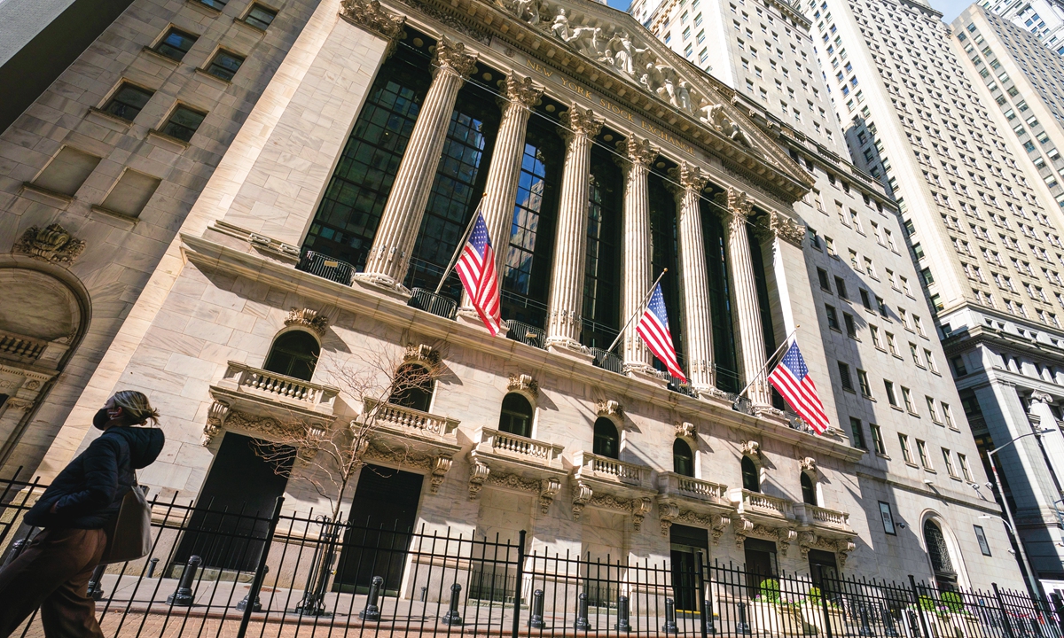 A pedestrian passes the New York Stock Exchange on January 24, 2022. Photo: VCG