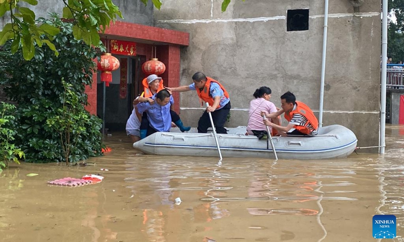 Photo taken with a mobile phone on June 13, 2022 shows rescuers evacuating stranded people in flood water in Quannan County, east China's Jiangxi Province.(Photo: Xinhua)