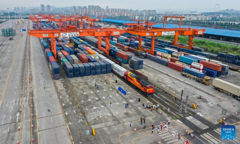 In this aerial photo, an outbound international freight train is about to depart from a station in southwest China's Chongqing, June 16, 2022. The first outbound international freight train for test from China's Chongqing to South Asia pulled out of a station in southwest China's Chongqing Municipality on Thursday. The new route from Chongqing to Nepal's capital Kathmandu can save about 20 days on the way compared with traditional logistics routes.(Photo: Xinhua)