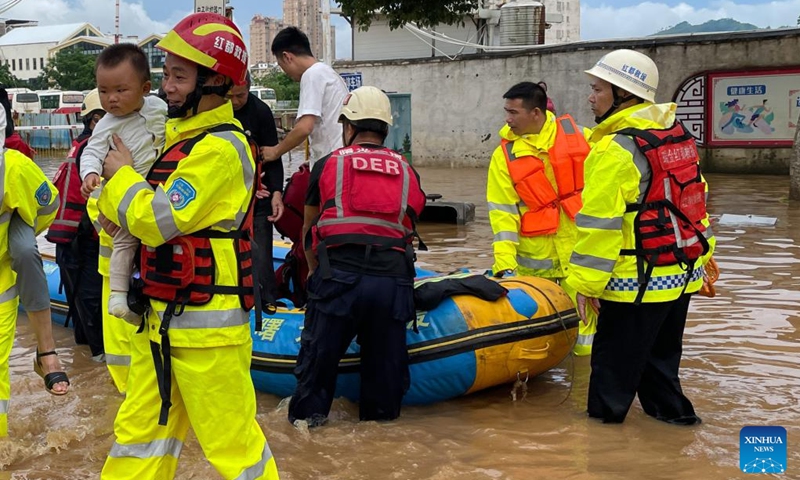 Photo taken with a mobile phone on June 14, 2022 shows rescuers evacuating stranded people in flood water in Ruijin City, east China's Jiangxi Province.(Photo: Xinhua)