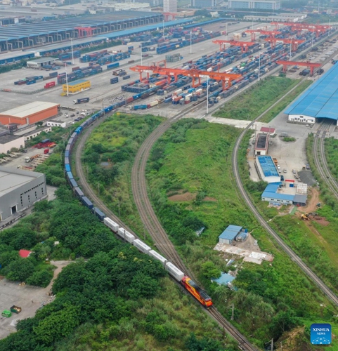 In this aerial photo, an outbound international freight train departs from a station in southwest China's Chongqing, June 16, 2022. The first outbound international freight train for test from China's Chongqing to South Asia pulled out of a station in southwest China's Chongqing Municipality on Thursday. The new route from Chongqing to Nepal's capital Kathmandu can save about 20 days on the way compared with traditional logistics routes.(Photo: Xinhua)
