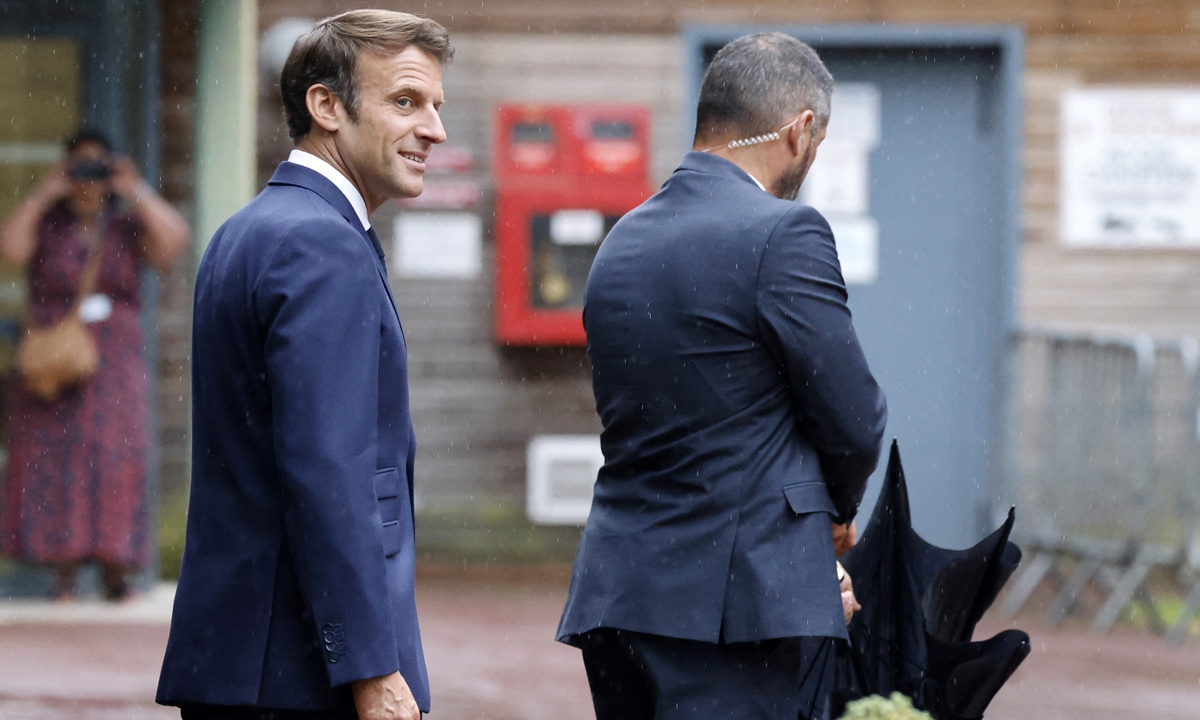 French President Emmanuel Macron (left) looks on as he leaves a polling station after casting his vote in the second stage of French parliamentary elections in Le Touquet, northern France on June 19, 2022. One month on from Macron's reelection as French president, he is hoping to hold onto his majority in parliament but faces a new super coalition on the left. Photo: AFP