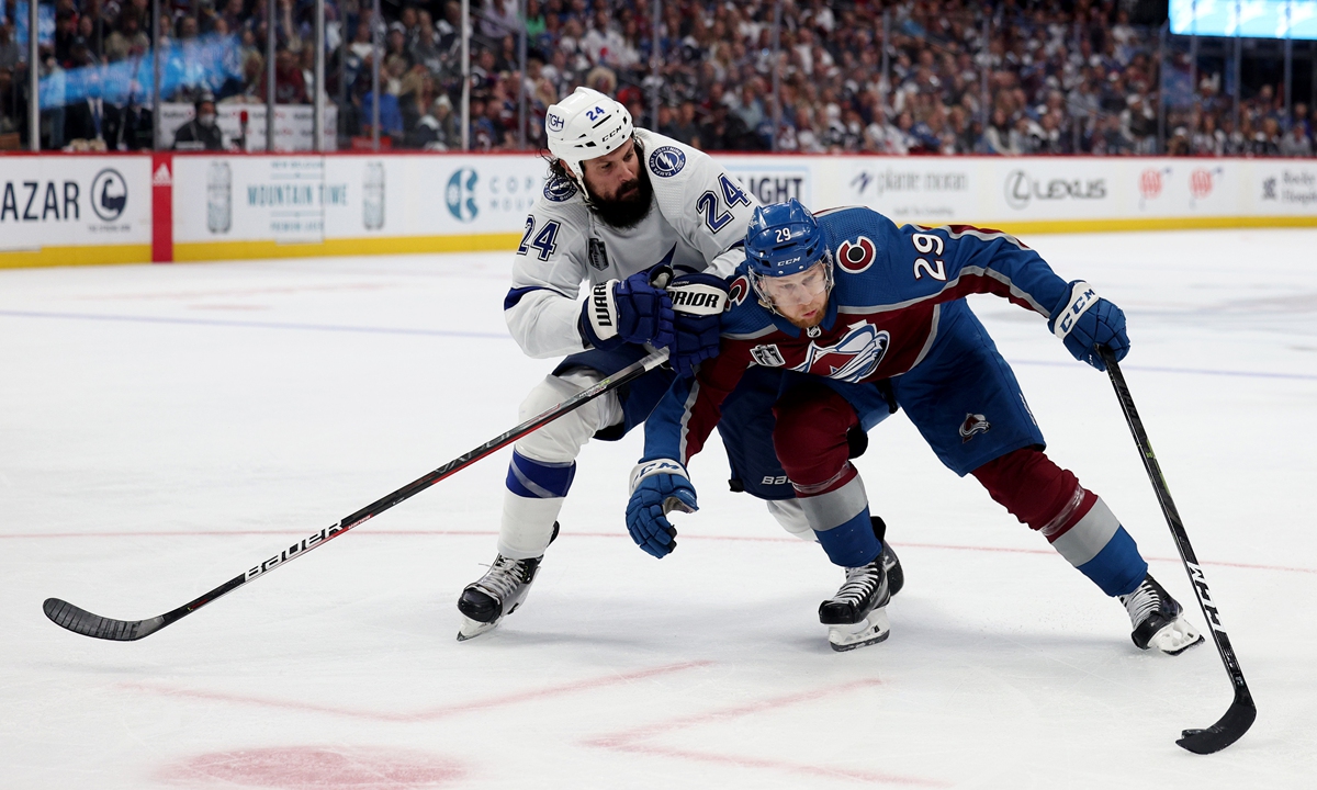 Nathan MacKinnon (right) of the Colorado Avalanche controls the puck against Zach Bogosian of the Tampa Bay Lightning on June 18, 2022 in Denver, Colorado. Photo: VCG