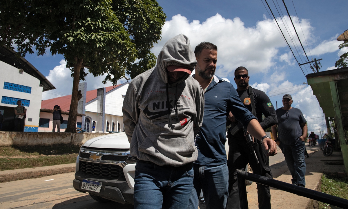 SJefferson da Silva Lima (left), a third suspect in the killing of British journalist Dom Phillips and Brazilian indigenous expert Bruno Pereira, is escorted to a hearing in Atalaia do Norte, Amazonas State, Brazil, on June 18, 2022. Photo: AFP