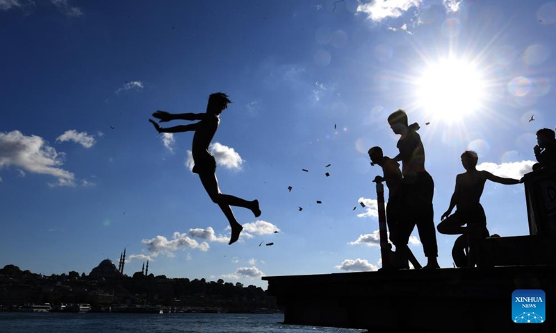 A man jumps into the Bosphorus Strait in Istanbul, Turkey on June 18, 2022.Photo:Xinhua