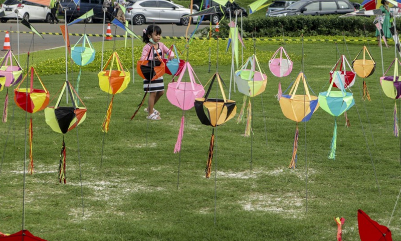A girl views kites during the World Kite Festival in Bogor, West Java, Indonesia, June 19, 2022.Photo:Xinhua