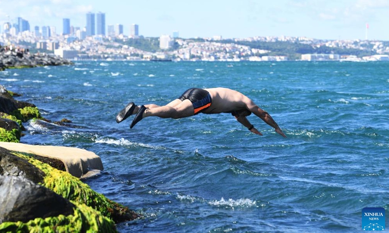 A man jumps into the Bosphorus Strait in Istanbul, Turkey on June 18, 2022.Photo:Xinhua