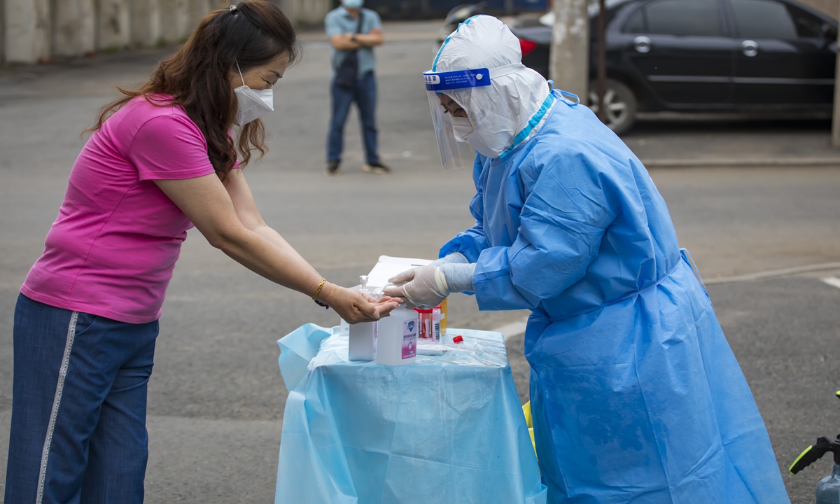 A medical worker disinfects for a resident during nucleic acid testing on Monday in Jilin, Northeast China's Jilin Province. Photo: VCG