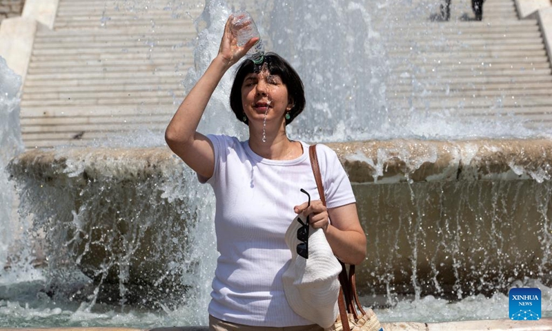 A woman pours water on her head during a heatwave in Athens, Greece, on June 22, 2022.(Photo: Xinhua)