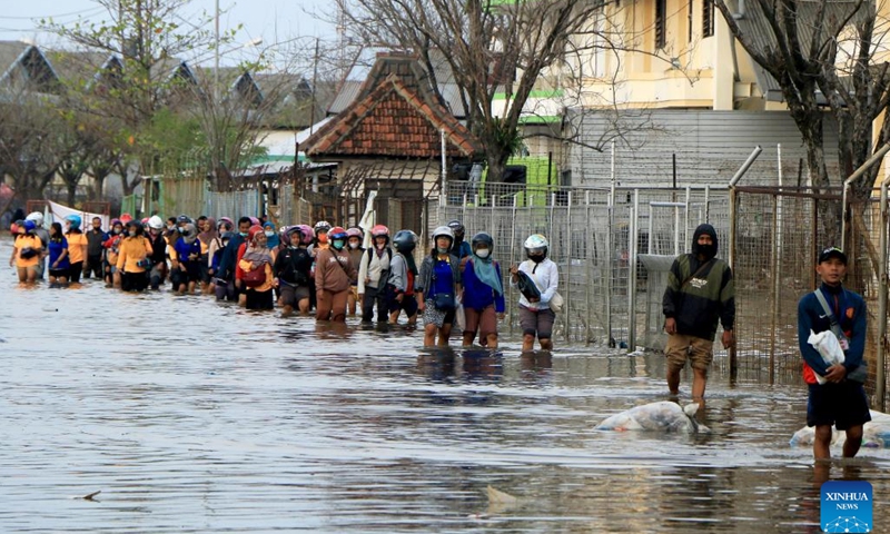 Menschen waten nach Hochwasser im Hafen von Tanjung Emas an der Küste von Semarang, Zentral-Java, Indonesien, am 21. Juni 2022 durch Hochwasser. (Foto: Xinhua)