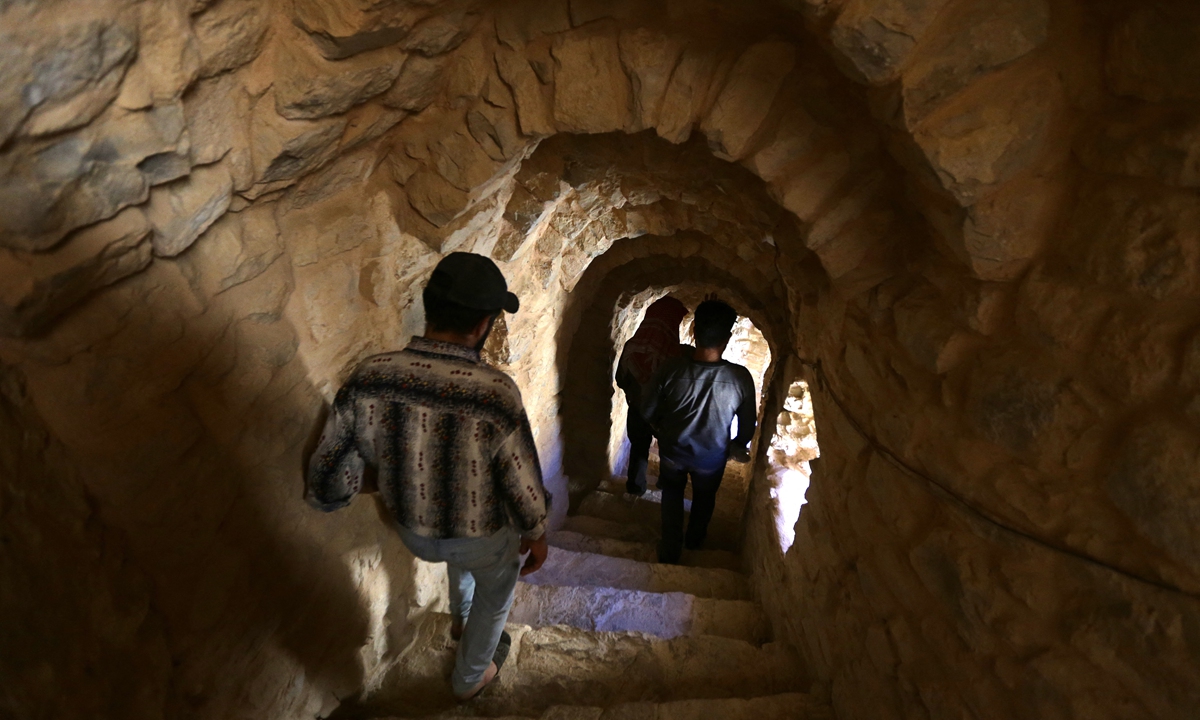 People walk down a stairway at Deir Mar Moussa Al-Habashi on June 11, 2022. Photo: AFP