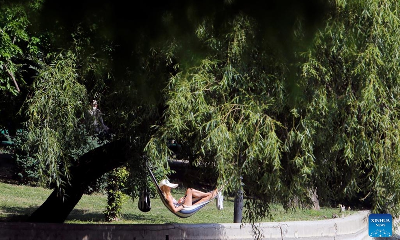 A woman rests in a hammock in the shade during a heat wave at a park in downtown Bucharest, Romania, on June 21, 2022.(Photo: Xinhua)