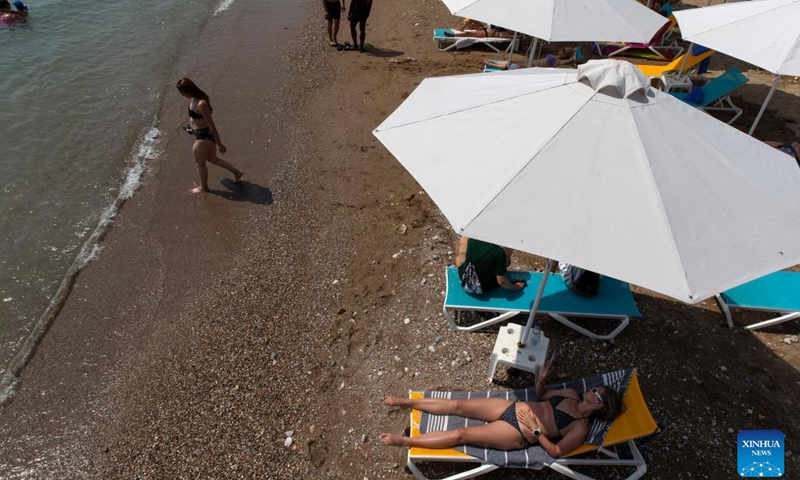 People spend time on a beach during a heatwave in Athens, Greece, on June 22, 2022.(Photo: Xinhua)