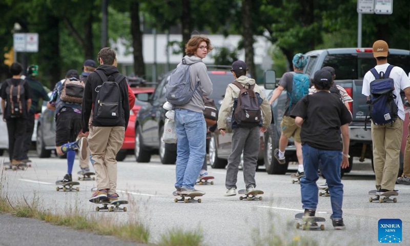 People ride along a road during the Go Skateboarding Day event in Vancouver, British Columbia, Canada, on June 21, 2022. Skateboarders rolled down the streets of Vancouver in celebration of the annual Go Skateboarding Day which is observed on June 21.(Photo: Xinhua)