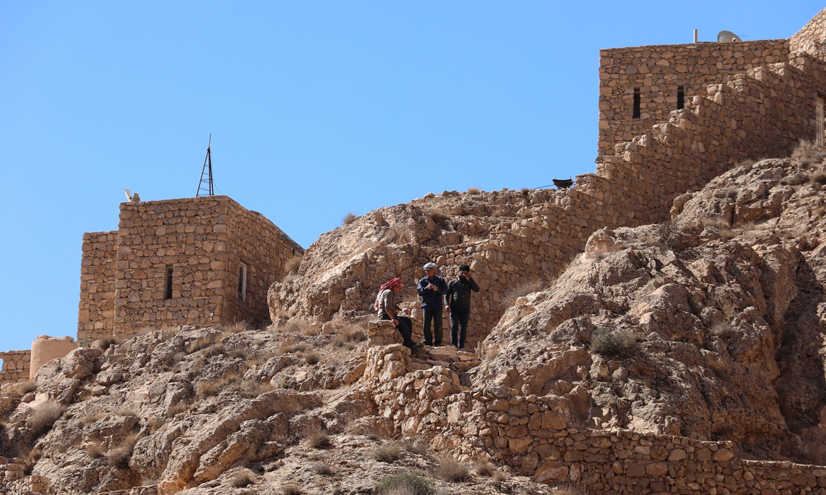 People walk down a stairway at Deir Mar Moussa Al-Habashi (St Moses the Ethiopian monastery), one of the ancient monasteries in Syria in the mountains near the desert in the Nabek area in Damascus countryside, on June 11, 2022. Photos: AFP