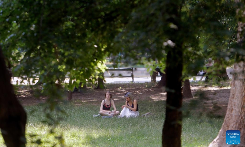 People sit in the shade during a heat wave at a park in downtown Bucharest, Romania, on June 21, 2022.(Photo: Xinhua)