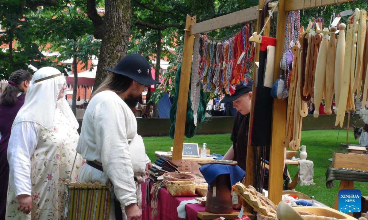 Tourists visit a stall at the annual Medieval Market in Turku, Finland, June 30, 2022. The annual Medieval Market, one of the largest historical events in Finland, kicked off on Thursday. Visitors enjoy a robust medieval atmosphere with stall owners and actors dressed in medieval style costumes at the market. Photo:Xinhua