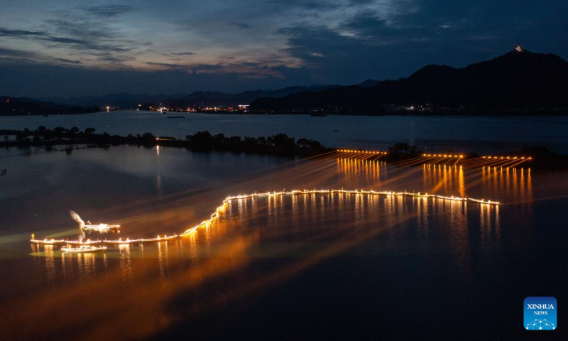 Aerial photo taken on July 3, 2022 shows lights on fishing boats during a folk festival in Sandu Fishing Village of Jiande City, east China's Zhejiang Province. (Xinhua/Xu Yu)